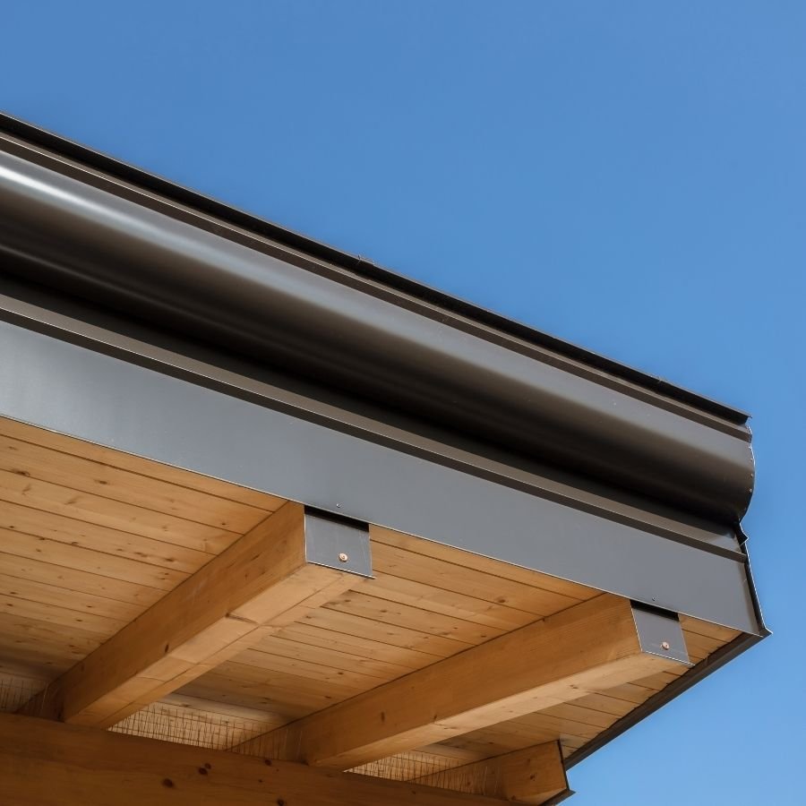 Construction worker performing fascia repair on a residential roof.