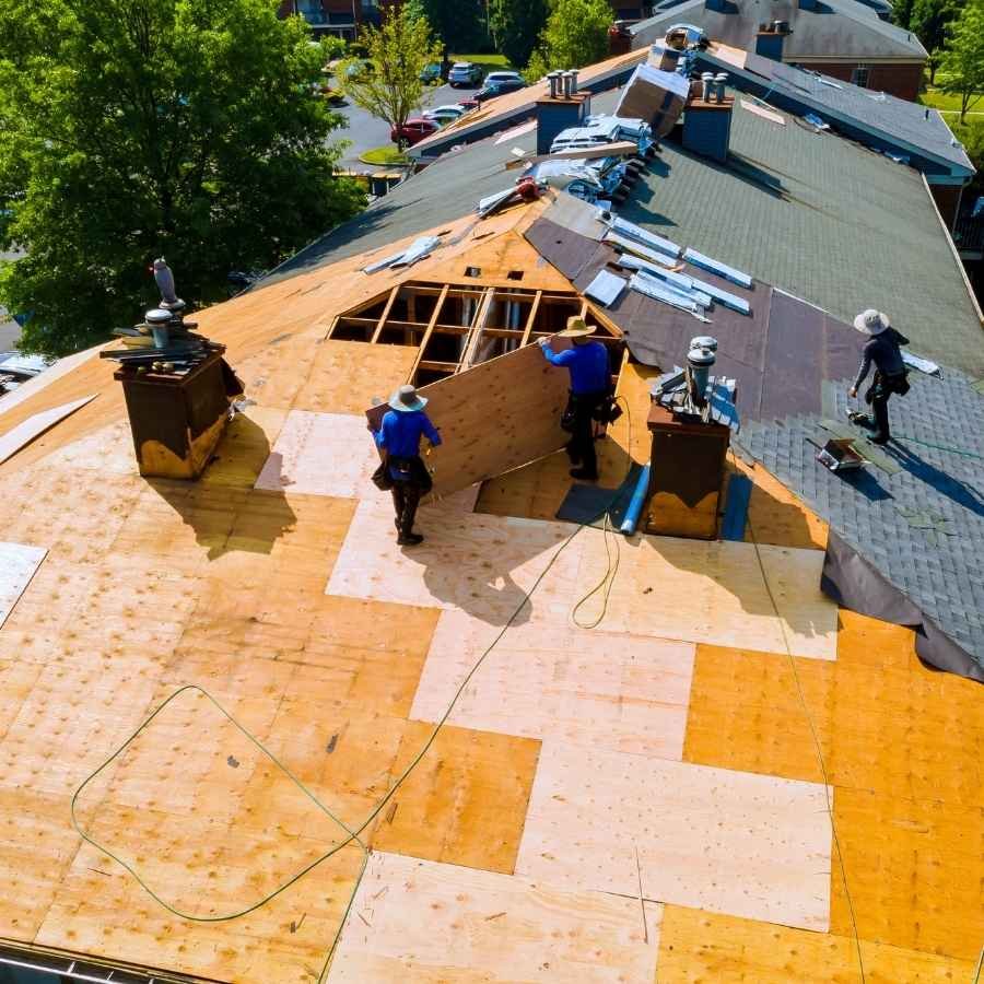 Hidden Hills roofing technician removing old shingles during a roof replacement.